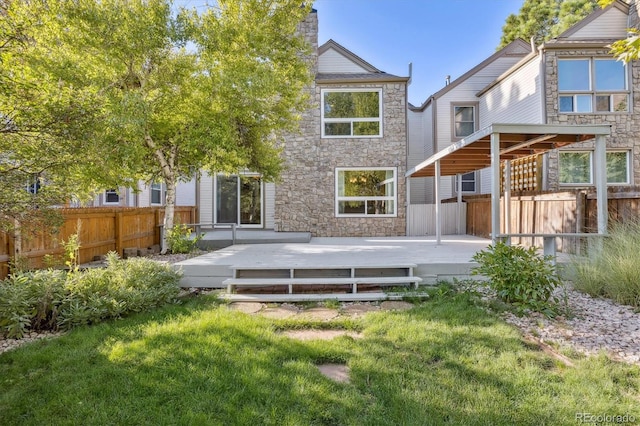 back of property with a lawn and a wooden deck