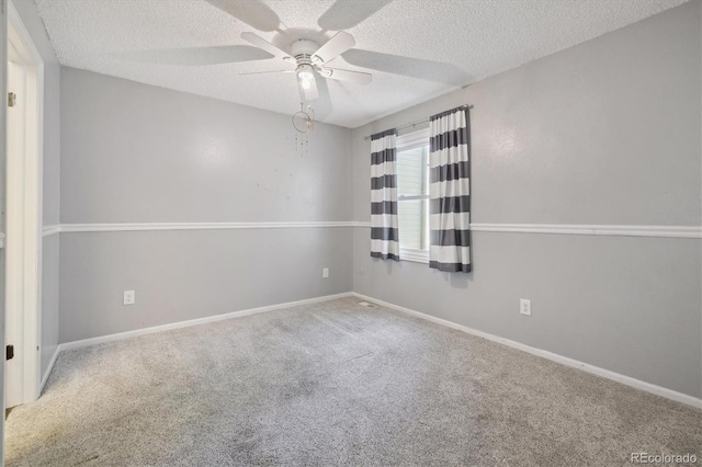 carpeted spare room with ceiling fan and a textured ceiling