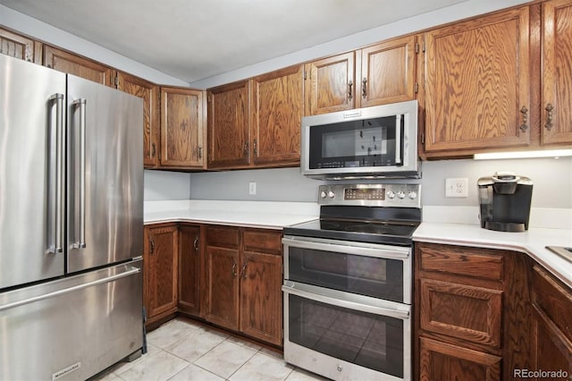 kitchen featuring light tile patterned floors and stainless steel appliances