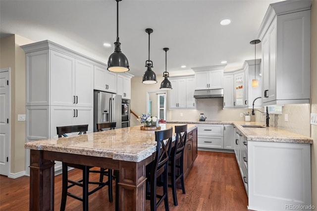 1113 Southbury Pl, Highlands Ranch, CO 80129 - kitchen featuring a sink, stainless steel fridge, recessed lighting, light stone counters, and a center island