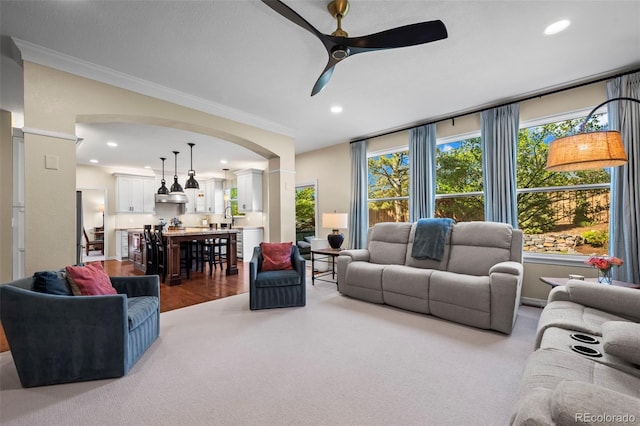 1113 Southbury Pl, Highlands Ranch, CO 80129 - living area featuring arched walkways, ornamental molding, ceiling fan, recessed lighting, and carpet flooring