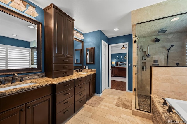 1113 Southbury Pl, Highlands Ranch, CO 80129 - ensuite bathroom with a stall shower, double vanity, a bath, baseboards, and recessed lighting