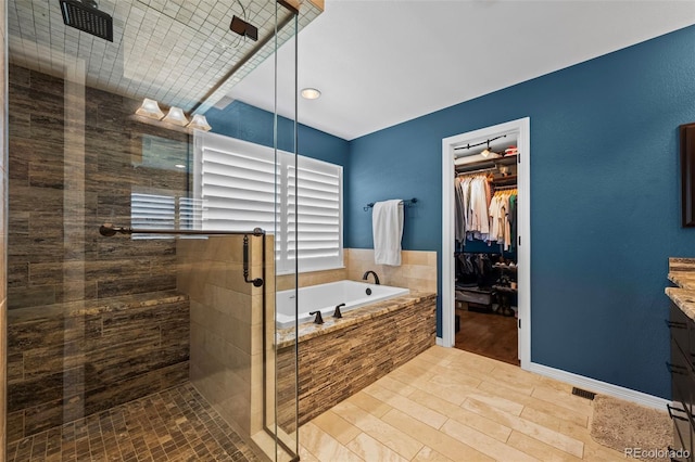 1113 Southbury Pl, Highlands Ranch, CO 80129 - full bath featuring a garden tub, vanity, a shower stall, a walk in closet, and wood finished floors