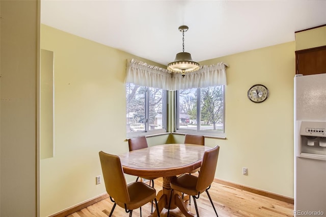 dining room with baseboards and light wood-type flooring