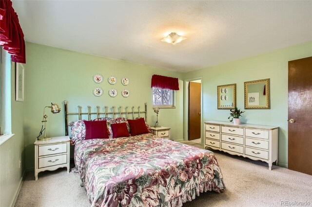 bedroom featuring light colored carpet and baseboards