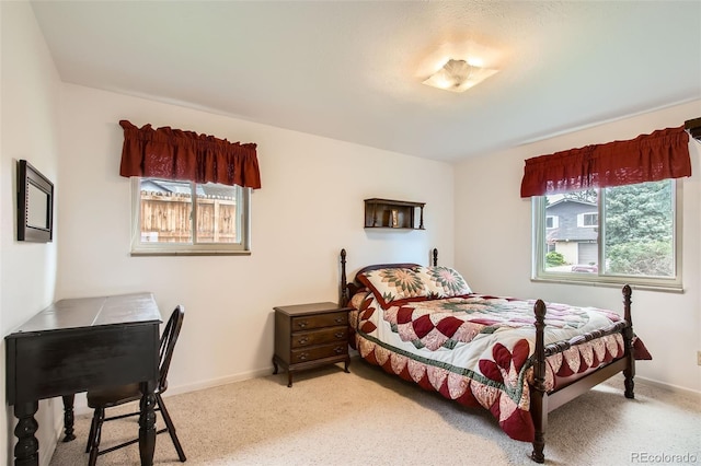 bedroom with baseboards, light colored carpet, and multiple windows