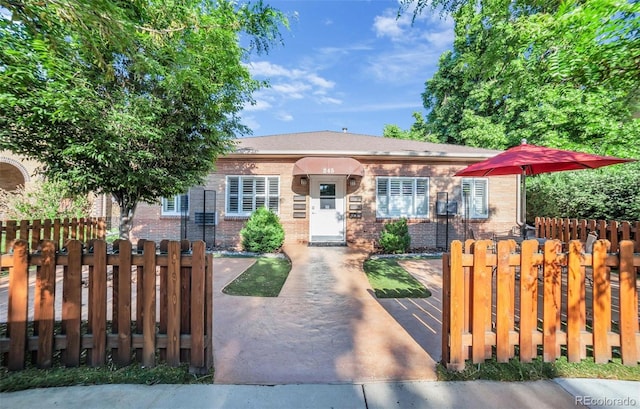 view of front of house featuring a fenced front yard and brick siding