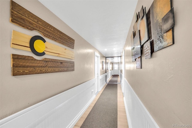 hallway featuring wainscoting and light wood finished floors