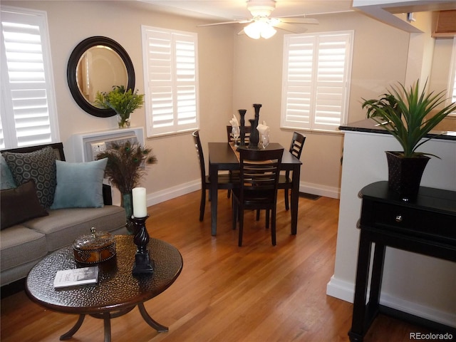 dining room featuring baseboards, a ceiling fan, and light wood-style floors