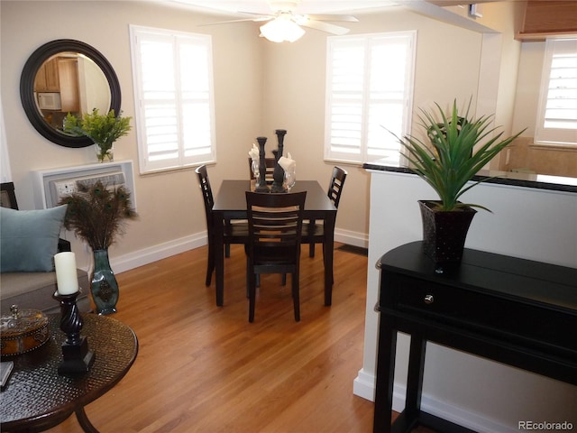 dining area with a ceiling fan, baseboards, and wood finished floors