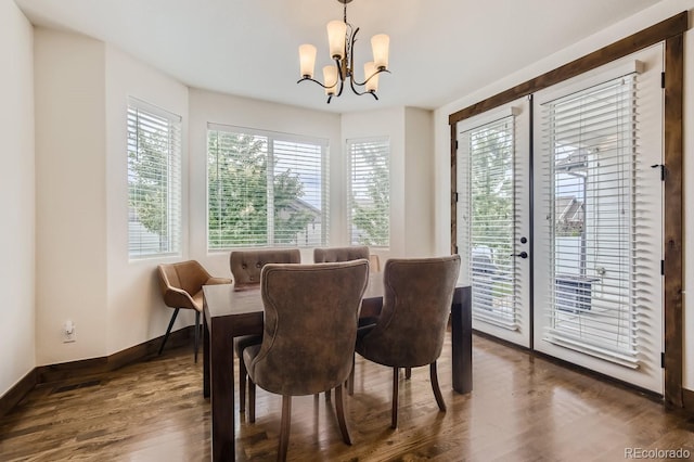 dining room with a chandelier, baseboards, and wood finished floors