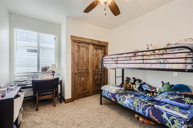 bedroom featuring a closet, light carpet, ceiling fan, and baseboards