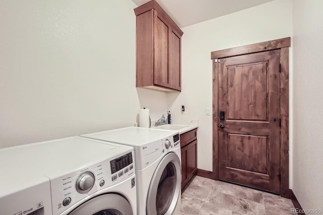 laundry room featuring cabinet space, a sink, washer and clothes dryer, and baseboards