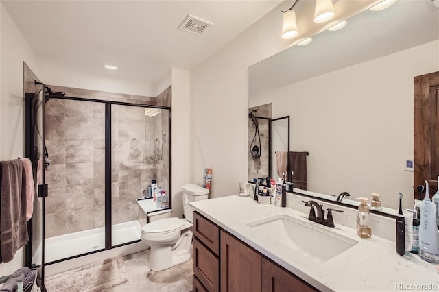 bathroom with toilet, a stall shower, visible vents, and vanity