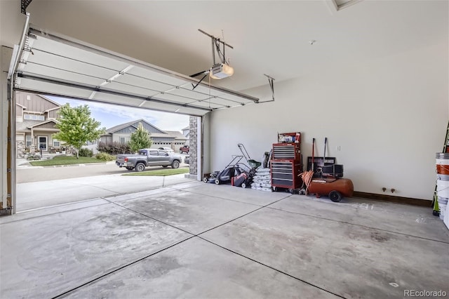 garage featuring a garage door opener and baseboards