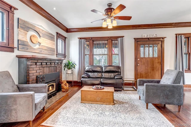 1399 Newton St, Denver, CO 80204 - living area featuring ornamental molding, ceiling fan, wood finished floors, baseboards, and a brick fireplace