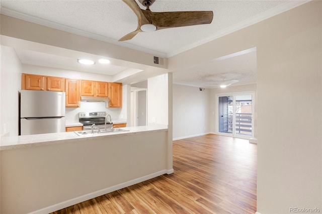 kitchen with ceiling fan, light countertops, freestanding refrigerator, under cabinet range hood, and light wood-style flooring