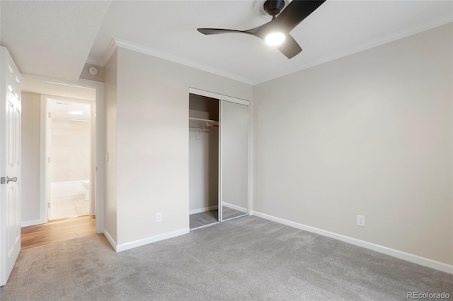 unfurnished bedroom featuring carpet floors, ornamental molding, a closet, baseboards, and ceiling fan