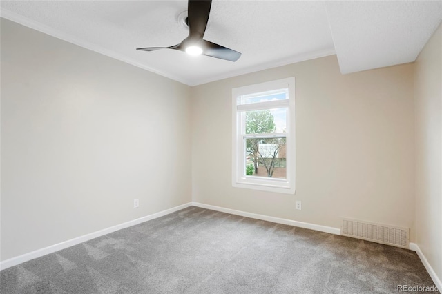 carpeted empty room with crown molding, ceiling fan, visible vents, and baseboards