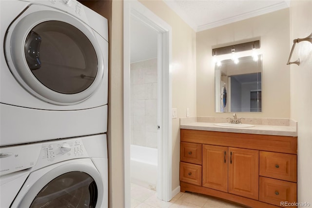 7665 E Eastman Ave Unit 302B, Denver, CO 80231 - washroom with stacked washer / dryer, ornamental molding, light tile patterned flooring, a sink, and laundry area