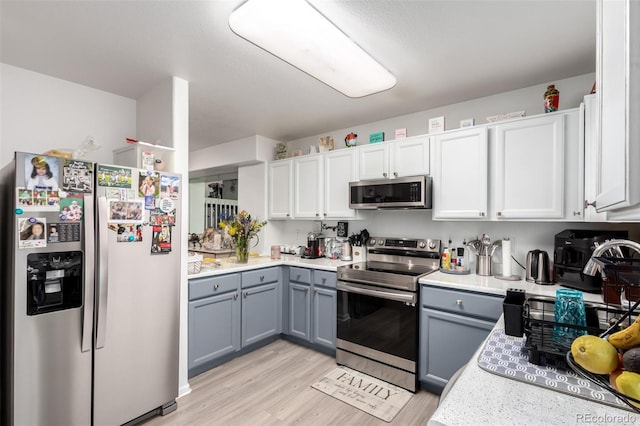 1885 S Quebec Way Unit G 106, Denver, CO 80231 - kitchen with appliances with stainless steel finishes, gray cabinets, light wood-style flooring, light countertops, and white cabinets