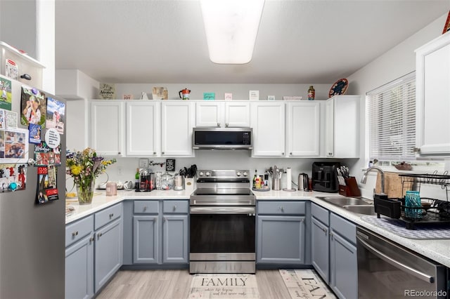 1885 S Quebec Way Unit G 106, Denver, CO 80231 - kitchen featuring appliances with stainless steel finishes, gray cabinets, light countertops, and light wood-type flooring