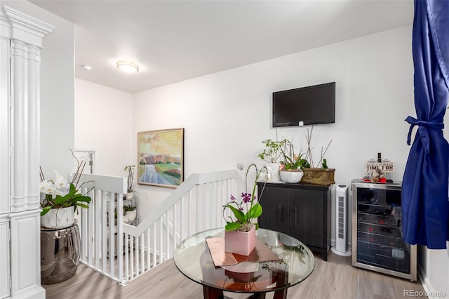 1885 S Quebec Way Unit G 106, Denver, CO 80231 - living area featuring wood finished floors, decorative columns, and beverage cooler