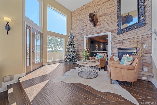 living room featuring a stone fireplace and a high ceiling