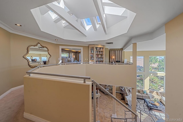 interior space featuring a skylight, light carpet, ornamental molding, and a kitchen island