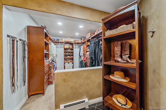 walk in closet with a baseboard heating unit and carpet flooring