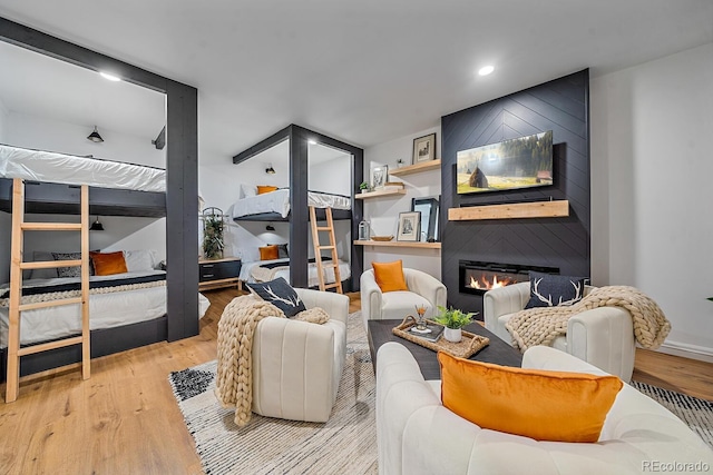 living room featuring light hardwood / wood-style floors and a large fireplace