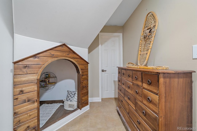 hall featuring light tile patterned floors and baseboards