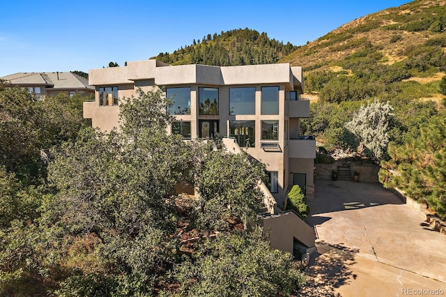 exterior space featuring a mountain view and stucco siding