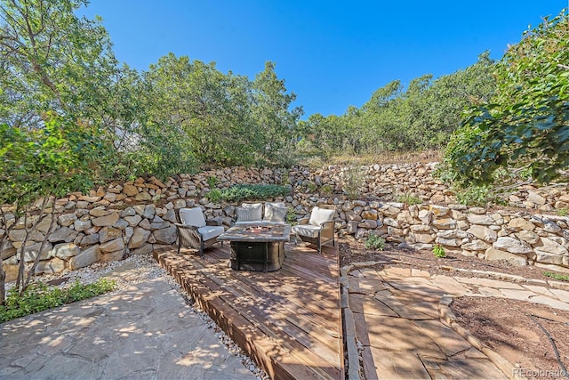 view of patio / terrace featuring an outdoor fire pit and a wooden deck