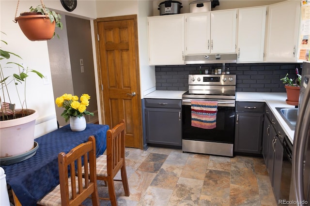 11861 Claude Way, Northglenn, CO 80233 - kitchen with stainless steel electric stove, range hood, tasteful backsplash, stone tile floors, and light countertops