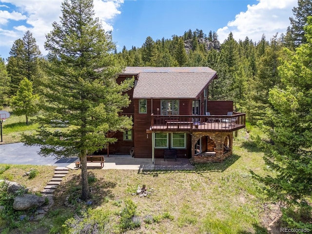 173 Silver Cloud Ln, Boulder, CO 80302 - rear view of house with a patio area, a deck, a forest view, and roof with shingles