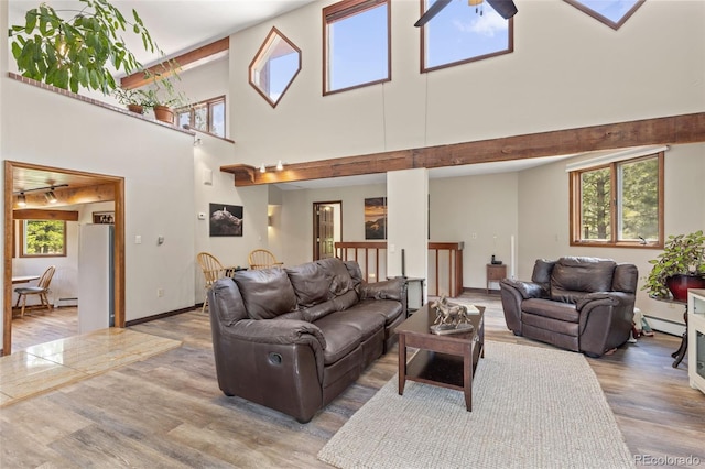 173 Silver Cloud Ln, Boulder, CO 80302 - living room featuring a baseboard heating unit, wood finished floors, a towering ceiling, and ceiling fan