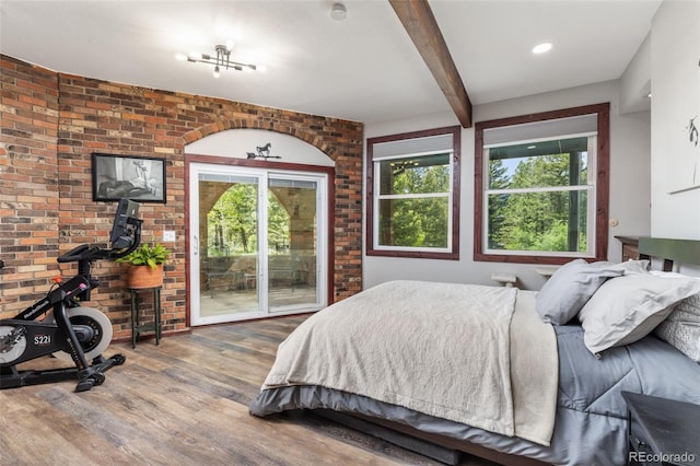 173 Silver Cloud Ln, Boulder, CO 80302 - bedroom featuring access to exterior, wood finished floors, beam ceiling, and brick wall