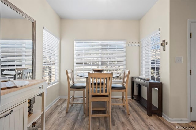 dining area with baseboards and light wood-type flooring