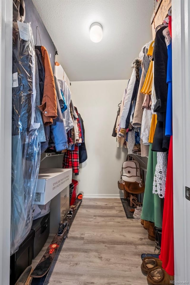 walk in closet with wood finished floors