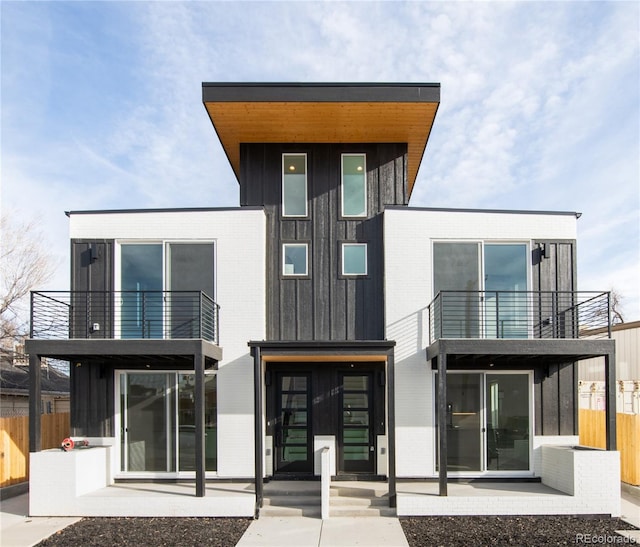 back of property featuring a balcony and a patio