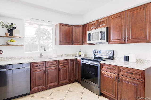 8651 Franklin St, Denver, CO 80229 - kitchen with light stone counters, light tile patterned floors, open shelves, appliances with stainless steel finishes, and a sink