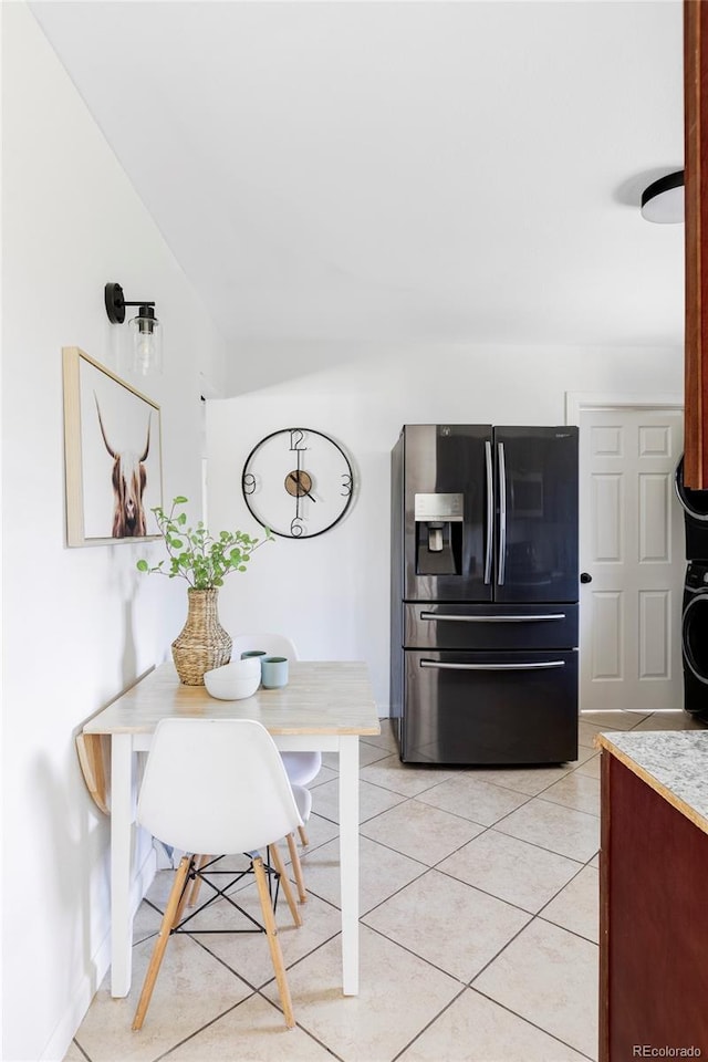 8651 Franklin St, Denver, CO 80229 - dining space with light tile patterned floors, stacked washer / drying machine, and baseboards