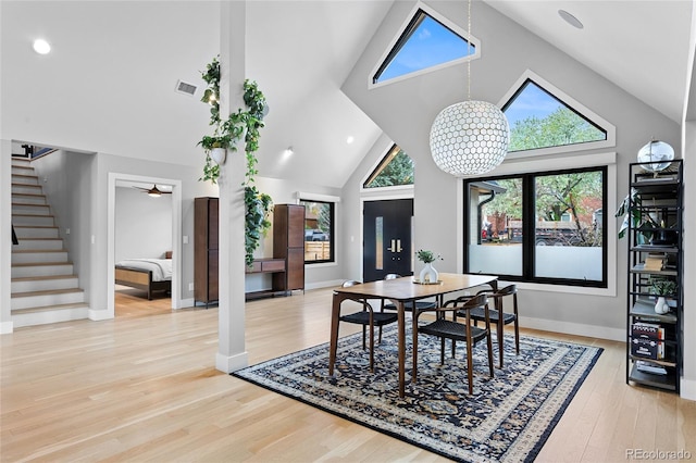 5859 E Ida Pl, Greenwood Village, CO 80111 - dining room with visible vents, baseboards, high vaulted ceiling, stairway, and light wood-type flooring