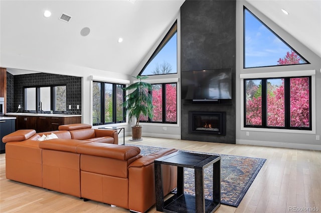 5859 E Ida Pl, Greenwood Village, CO 80111 - living room with high vaulted ceiling, visible vents, a large fireplace, and light wood-type flooring