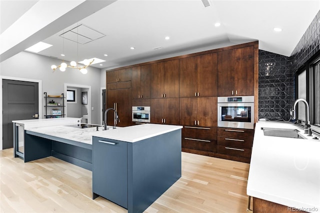 5859 E Ida Pl, Greenwood Village, CO 80111 - kitchen with a sink, light wood finished floors, a spacious island, and oven