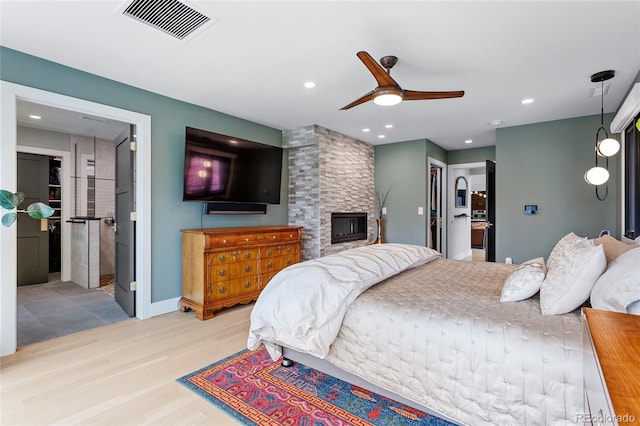 5859 E Ida Pl, Greenwood Village, CO 80111 - bedroom featuring connected bathroom, a fireplace, baseboards, wood finished floors, and visible vents