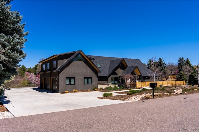 5859 E Ida Pl, Greenwood Village, CO 80111 - view of front facade with stucco siding, fence, concrete driveway, and a garage
