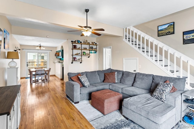 living room with hardwood / wood-style flooring and ceiling fan with notable chandelier