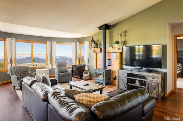 living room featuring dark wood-type flooring, a wood stove, and lofted ceiling